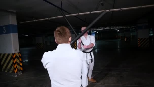 Zwei junge Männer im Kimono beim Training ihrer Kampfkünste. Schwertkampf — Stockvideo