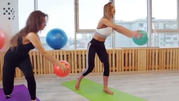 Jonge vrouwen doen fitness in de studio met een bal — Stockvideo