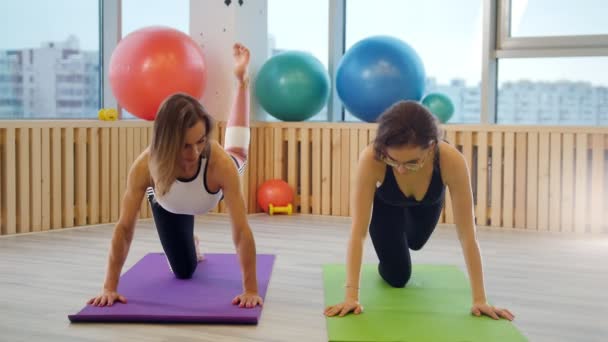 Młode kobiety Robienie yoga Studio na maty do jogi. Ćwiczenia na nogi — Wideo stockowe
