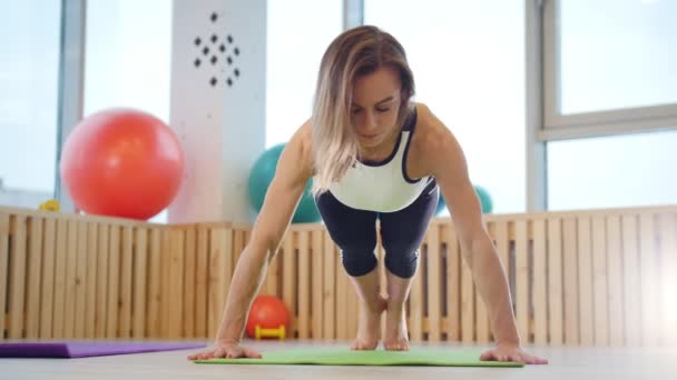 Mujer joven entrenadora de fitness haciendo flexiones en el estudio — Vídeos de Stock