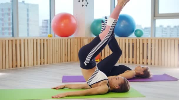 Mujeres jóvenes haciendo ejercicio en el estudio. Ejercicios de piernas — Vídeos de Stock