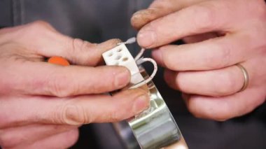 Endüstriyel konsept. İşi yapmak için telleri ayrıntılı olarak bağlayan bir işçi