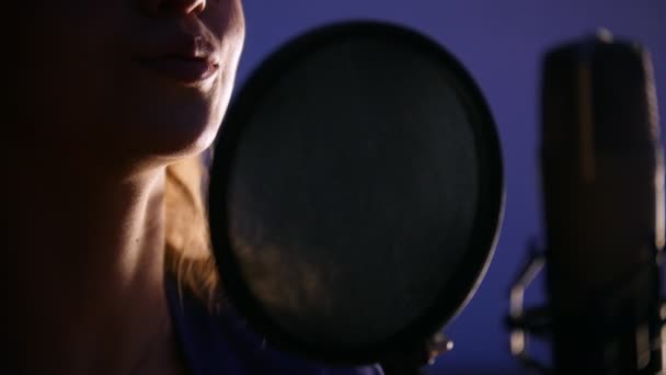 Uma jovem mulher gravando uma música no estúdio — Vídeo de Stock