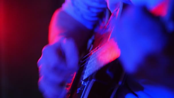 Uma pessoa tocando guitarra em iluminação de néon — Vídeo de Stock