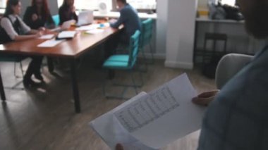 İş kavramı. Bir toplantısı çalışan ekip. Belgeleri ve takım bakarak bir adam getiriyor