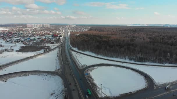 Uma vista aérea em uma estrada no inverno. Carros na estrada. Grande intercâmbio de tráfego — Vídeo de Stock