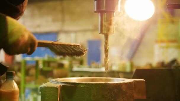 Construcción de plantas. Una máquina perforando un agujero en el detalle de hierro. Enfriar el taladro con agua — Vídeos de Stock