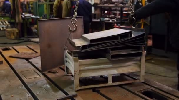 Concepto industrial. Una grúa elevadora traslada los detalles de hierro a un equipo de trabajo — Vídeos de Stock
