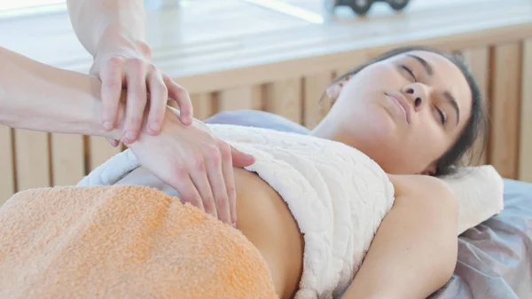 Uma jovem mulher a receber uma massagem. Massagear o estômago — Fotografia de Stock