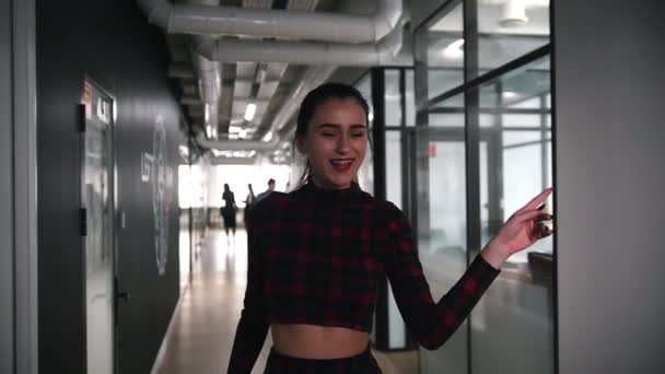 Возбужденная деловая женщина танцует в офисном коридоре, поет и швыряет газеты — стоковое видео