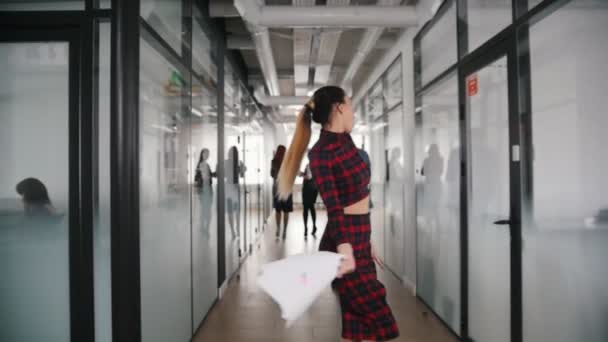 Una mujer de negocios sonriente emocional bailando en el pasillo de la oficina y tirando papeles al aire — Vídeo de stock