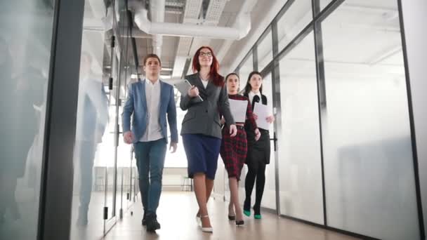 A successful business people walking through the corridor holding papers — Stock Video