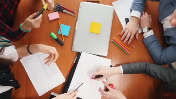 Concepto de negocio. Un equipo de trabajo productivo teniendo una conferencia y dibujando un horario en un papel — Vídeo de stock