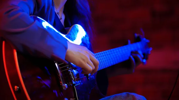 Молода жінка грає на гітарі в неоновому освітленні — стокове фото