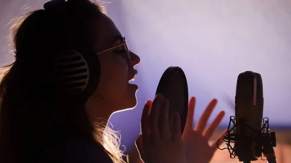 Une jeune femme chantant en studio — Photo