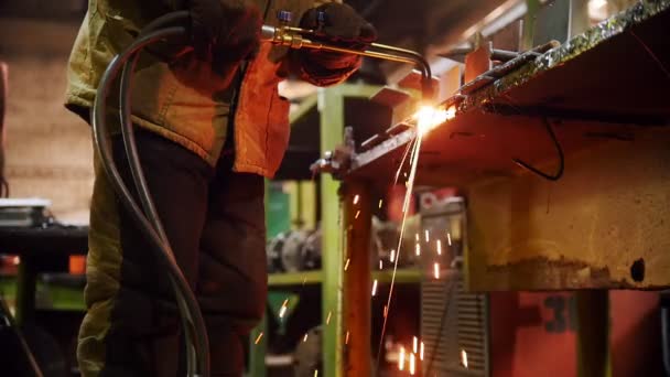 Construcción de plantas. Un hombre en su lugar de trabajo usando una máquina de soldadura. Calentando el lado del detalle — Vídeo de stock