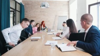 İnsanlar ofiste oturur masaya ve konferans başlar