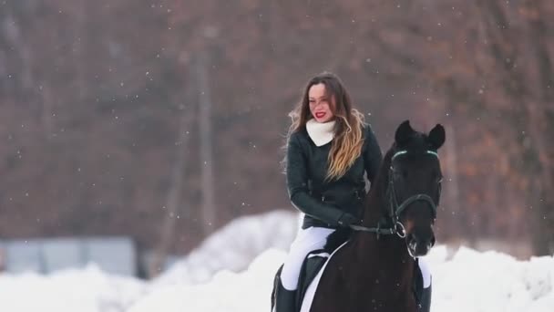 Winter time. Three women on horseback standing on snowy field in a village — Stock Video