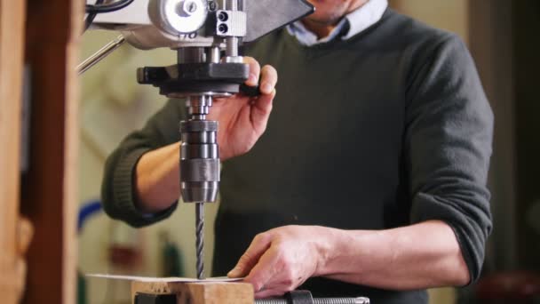 Un taladro industrial haciendo un agujero en una placa de metal — Vídeo de stock