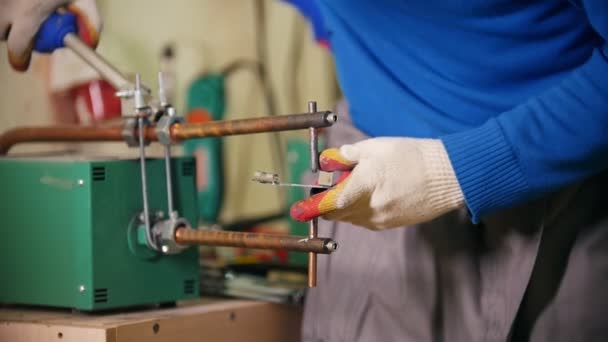 Construcción de plantas. Un trabajador haciendo un detalle usando una calefacción. Soldadura de las piezas de detalle juntas — Vídeo de stock