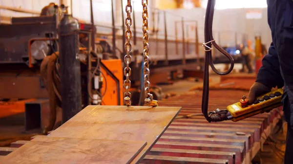 A man working with a lifting machine on the plant — Stock Photo, Image