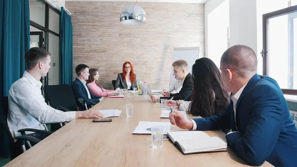 Gente en la conferencia de negocios en la oficina. Una jefa de jengibre sosteniendo una mano en los papeles — Foto de Stock