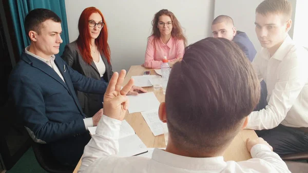 Personer på konferensen business talar av tabellen. En chef som talar till dem. — Stockfoto