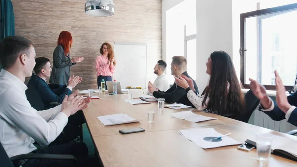 Una conferencia de negocios. Una mujer explica los gráficos en la pizarra y la gente aplaudiendo — Foto de Stock