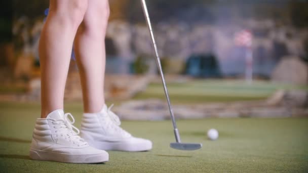 Una joven jugando mini golf en el interior. Piernas en el marco — Vídeos de Stock