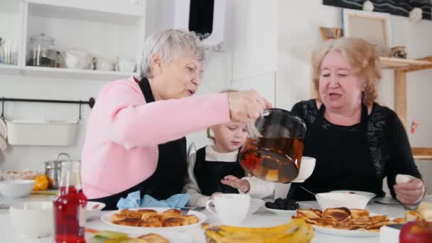 Familia comiendo panqueques y tomando té. Verter el té en las tazas — Vídeos de Stock