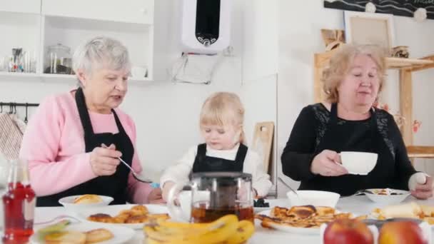 Familie isst Pfannkuchen und trinkt Tee — Stockvideo