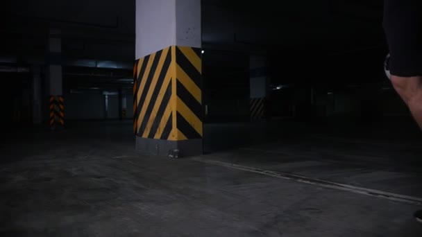 Parking souterrain. Un footballeur qui s'entraîne au football. Mener la balle autour d'un pilier en béton — Video