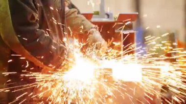 İnşaat fabrikası. Taşlama makinesini kullanan bir adam. Detay yan taşlama. Yangın pırıldları