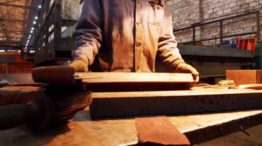 Endüstriyel inşaat fabrikası. Bir adam bir taşlama makinesi tutan ve hakkında işaretler ile detay kesmek için