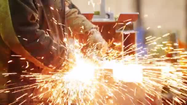 Bouw plant. Een man met behulp van een slijpmachine. Het slijpen van de zijkant van het detail. Vuur vonken — Stockvideo