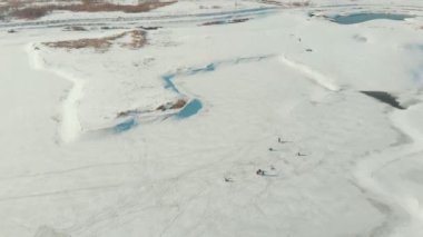 Donmuş nehirde oturan balıkçılar