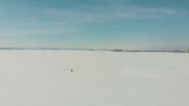 Pescatori seduti sul fiume ghiacciato e camminare sul ghiaccio — Video Stock