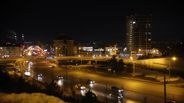 Una ciudad de luces y coches a caballo en las carreteras. Luces nocturnas . — Vídeo de stock