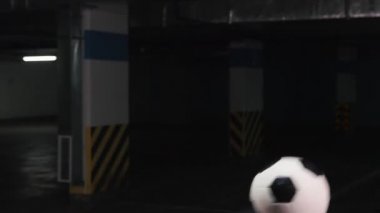 Kafası ve omuzlarında topu dengeleyen genç bir adam