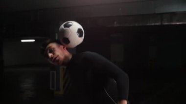 Kafası ve sırtında topu dengeleyen genç bir futbol adamı