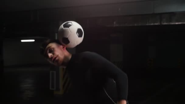 Ένας νεαρός ποδοσφαιριστής που ισορροπεί την μπάλα στο κεφάλι και την πλάτη του. — Αρχείο Βίντεο