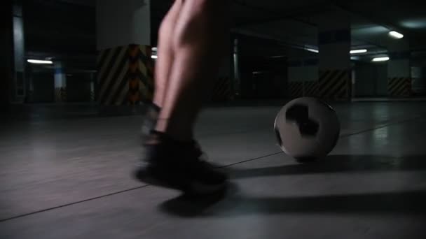 Piłka nożna człowieka prowadzącego piłkę. Szkolenie na podziemnym parkingu. — Wideo stockowe