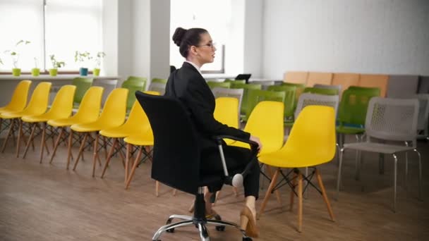 Concepto de negocio. Una mujer en gafas en el centro de negocios girando en una silla — Vídeos de Stock