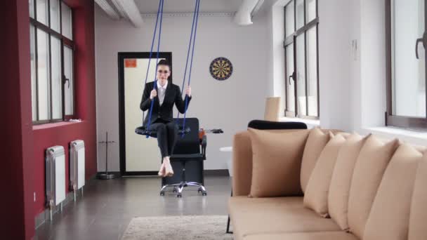 Бизнес-концепция. Женщина сидит на качелях в офисе — стоковое видео