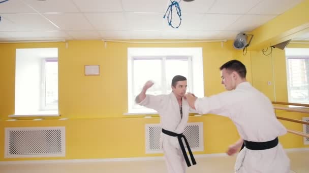 Dos hombres entrenando sus habilidades de aikido. Técnica de protección. Un hombre agarra a su oponente y lo arroja al suelo — Vídeo de stock