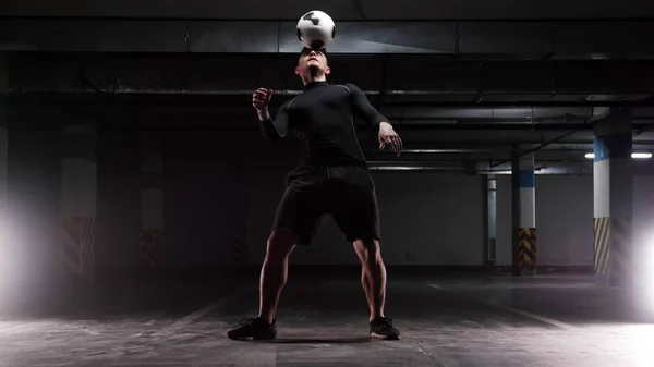 Un joven futbolista entrenando los trucos básicos con la pelota Equilibrando la pelota en la cabeza —  Fotos de Stock