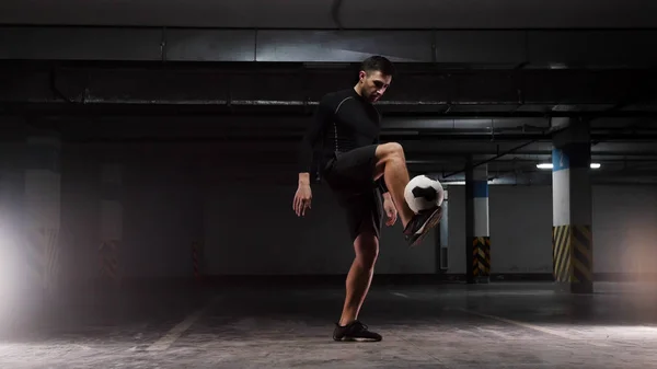 Un giovane uomo di calcio che allena i trucchi di base con la palla Bilanciamento della palla sui piedi sollevati — Foto Stock