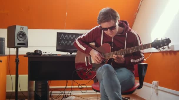 Un músico que trabaja en el estudio de sonido. Sintonizar la guitarra — Vídeos de Stock