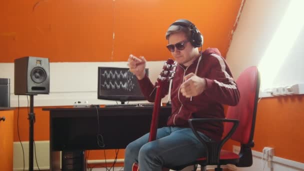 A musician man working in the sound studio. Putting on headphones — Stock Video