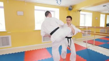 Dövüş sanatları. İki atletik adam parlak stüdyosunda Aikido becerilerini eğitti. Bir bacak vurmak ve yere rakibin atma koruma